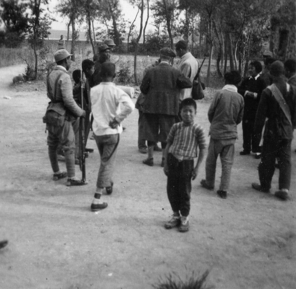 贝熙业(中间背影)与八路军战士及村民在一起。(中共北京市海淀区委宣传部供图)