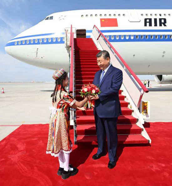 2025年9月23日下午,习近平率中央代表团乘专机抵达乌鲁木齐,出席新疆维吾尔自治区成立70周年庆祝活动。图为少先队员向习近平献花。新华社记者 谢环驰 摄