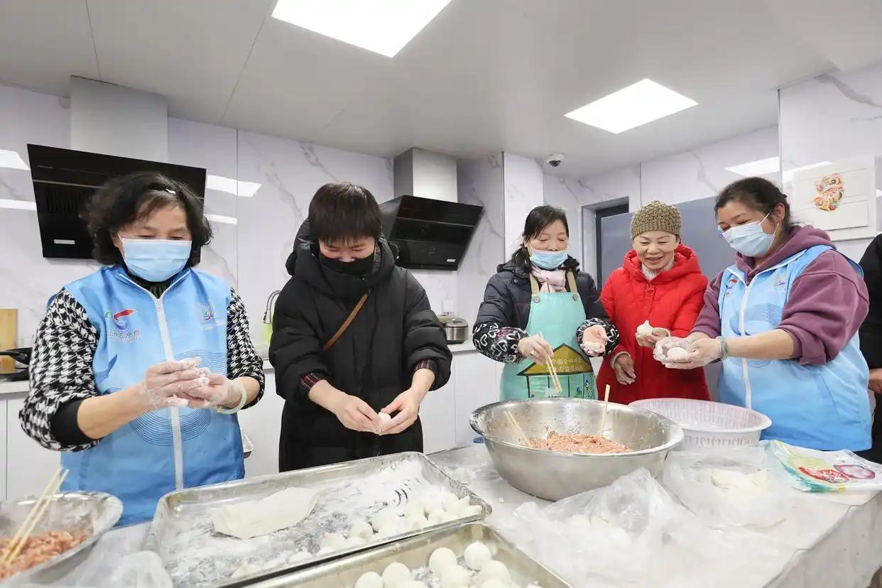 2024年2月23日,在上海闵行区新时代城市建设者管理者之家,住户和志愿者制作手工元宵。