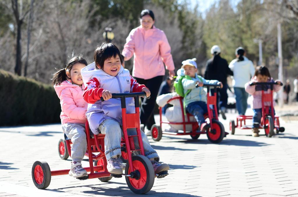 2025年3月19日,在内蒙古鄂尔多斯康巴什区一所托育园,老师陪伴孩子做体能游戏。