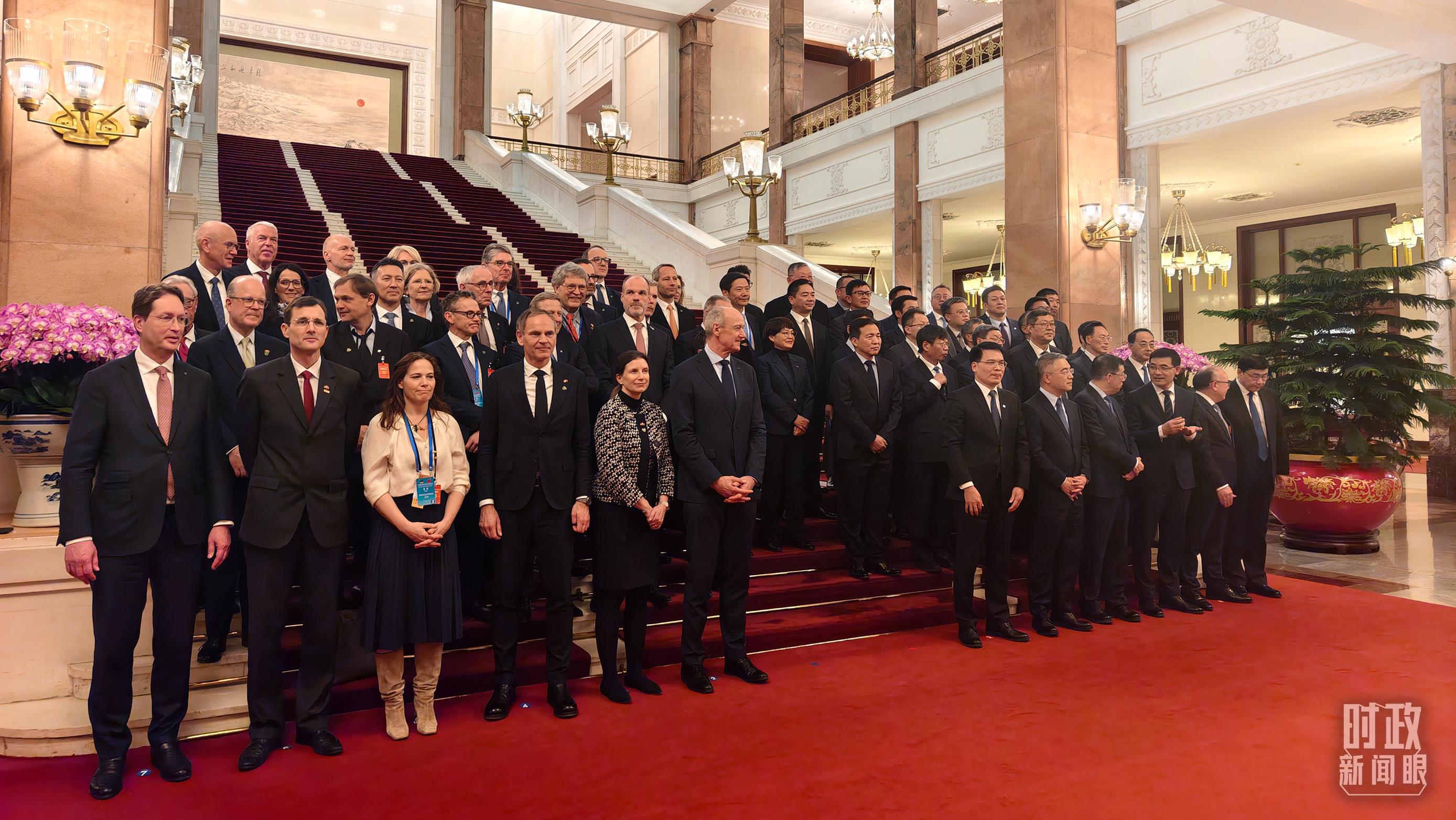 △2月25日下午，出席中德经济顾问委员会座谈会的中德企业代表在等待合影。（总台央视记者胡玮拍摄）