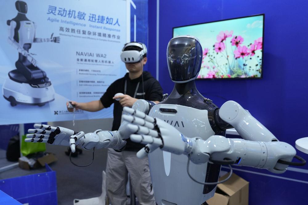 △在2025年世界互联网大会“互联网之光”博览会现场，一家企业工作人员展示人形机器人同步模仿精细动作。
